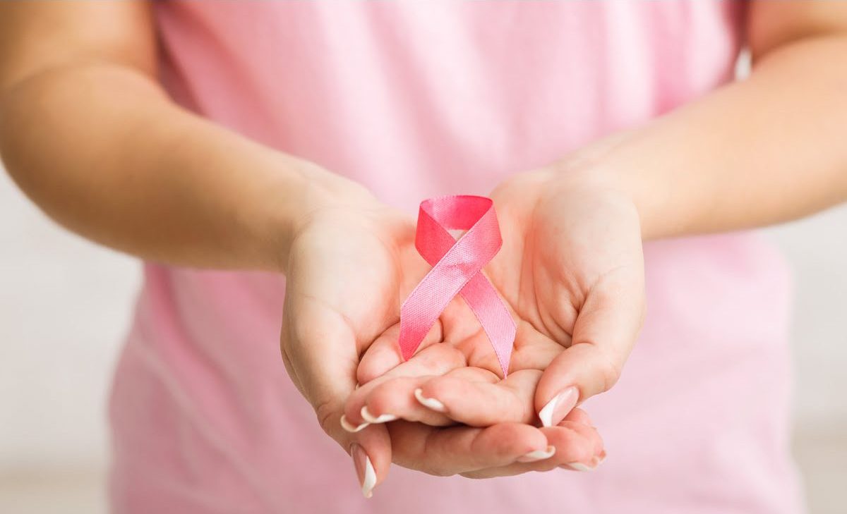 Pink ribbon cupped in a caregivers hands