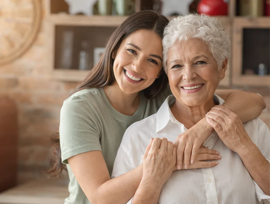 Young caregiver and senior man greeting each other with a friendly fist bump outdoors.